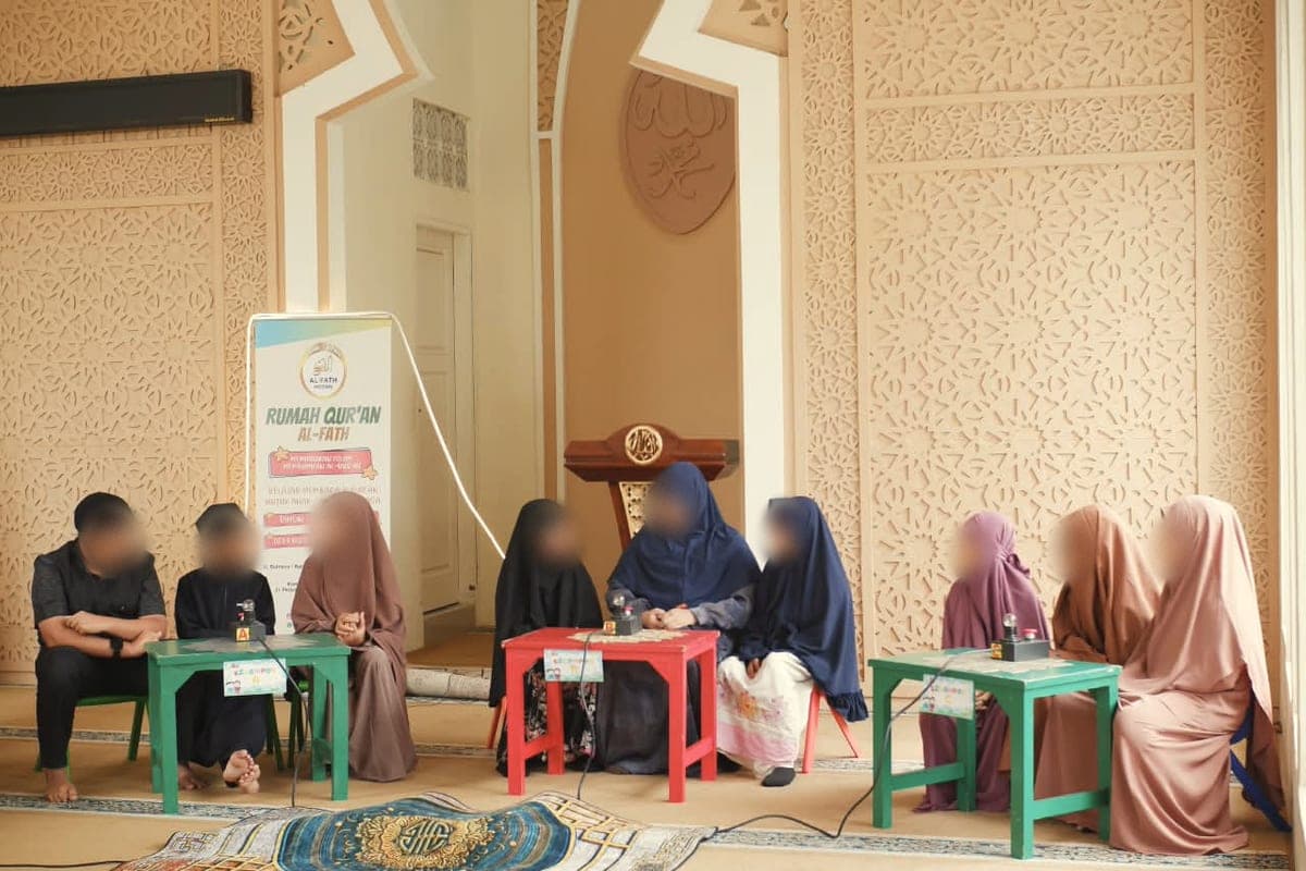 Santri putra dan putri duduk berkelompok di meja lomba bersama pendamping